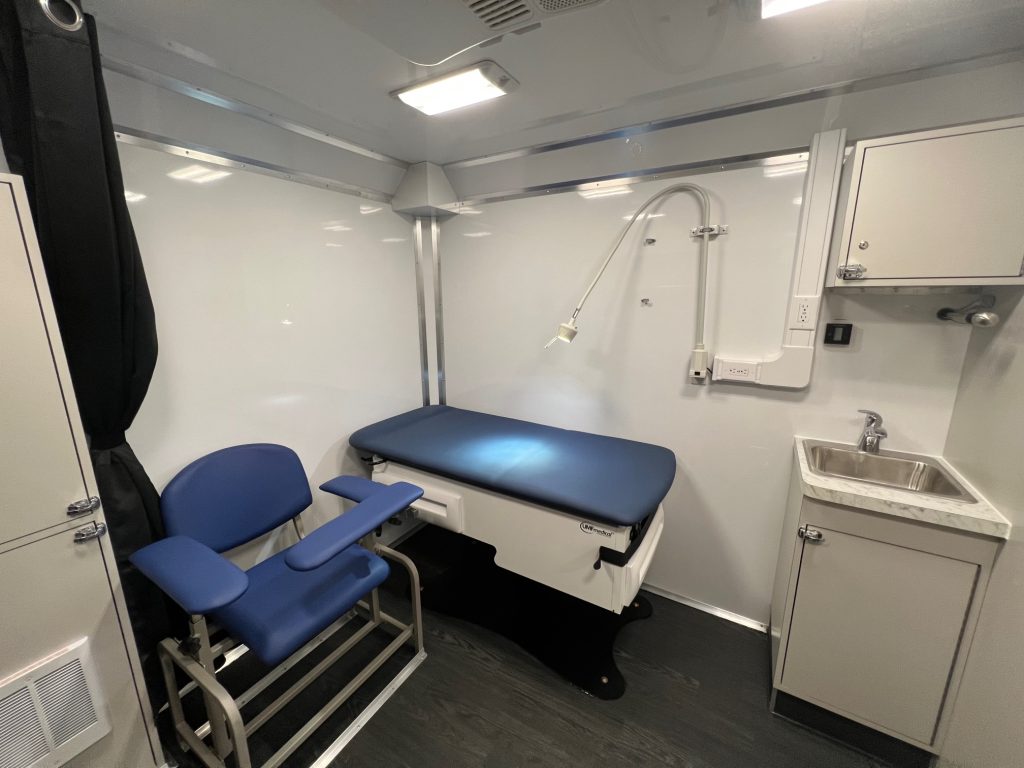 Main mobile medical clinic interior with blood draw chair and exam table